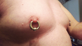 Schwere Piercing Ringe durch die Zitzen