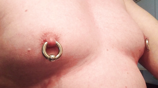 Schwere Piercing Ringe durch die Zitzen