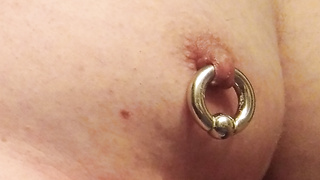 Schwere Piercing Ringe durch die Zitzen