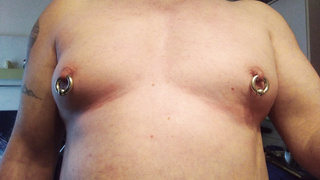 Schwere Piercing Ringe durch die Zitzen